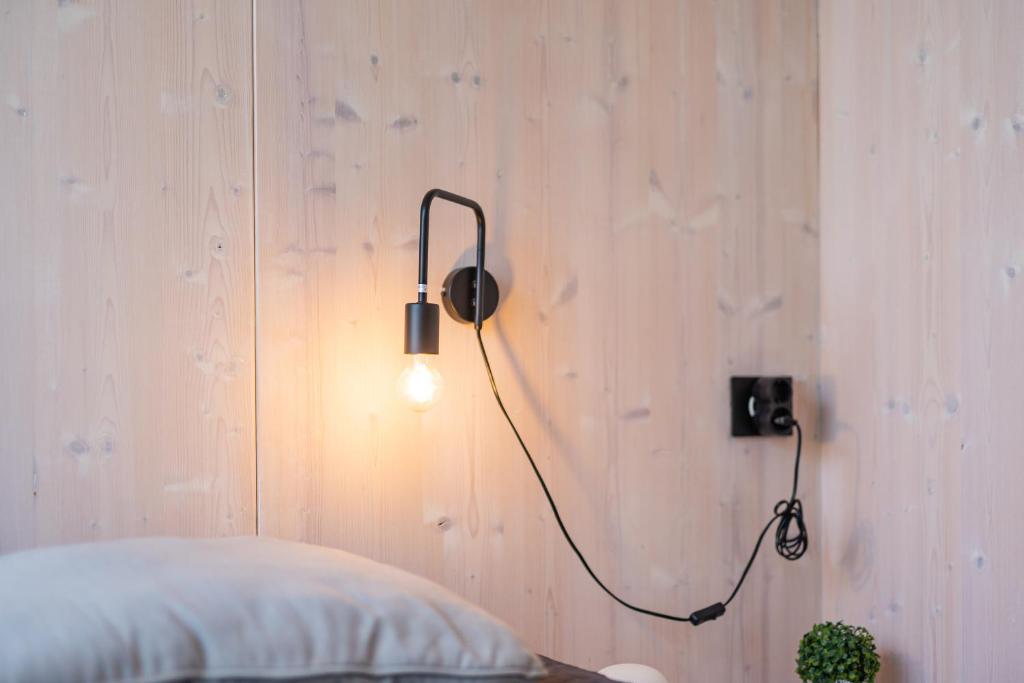 eine Lampe an einer Wand neben einem Bett in der Unterkunft BUQEZ VILLAS - VILLA 31 in Drage