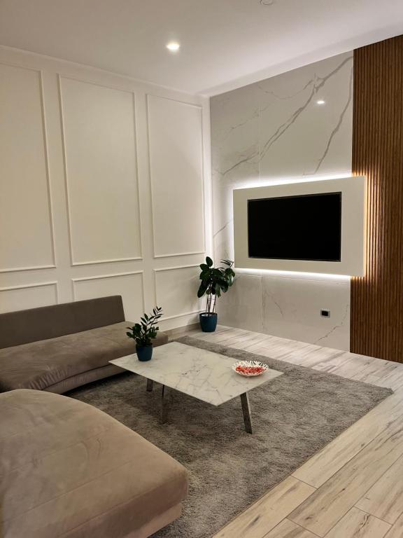 uma sala de estar com um sofá e uma televisão em Pergamena Bianca em Cava deʼ Tirreni