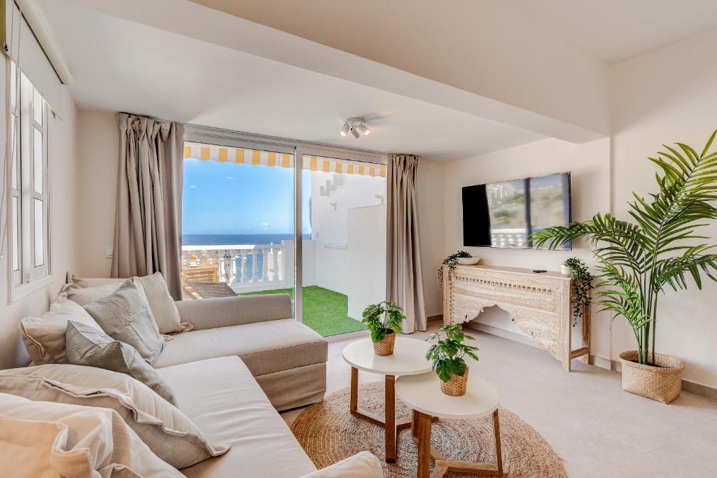 a living room with a couch and a fireplace at Good Mood - Sunny Seaview in Callao Salvaje