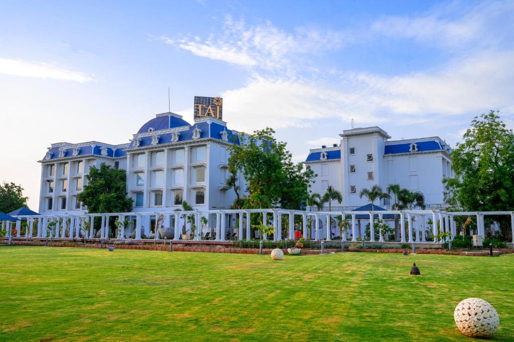 甘地訥格爾的住宿－Taj Gandhinagar Resort and Spa，前面有草坪的白色大建筑