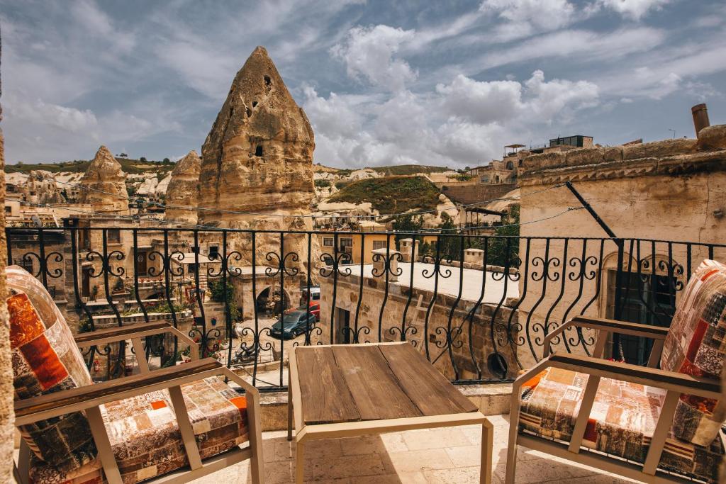 a balcony with a wooden table and a view of a city at Adelya Cave Hotel Apartments in Göreme