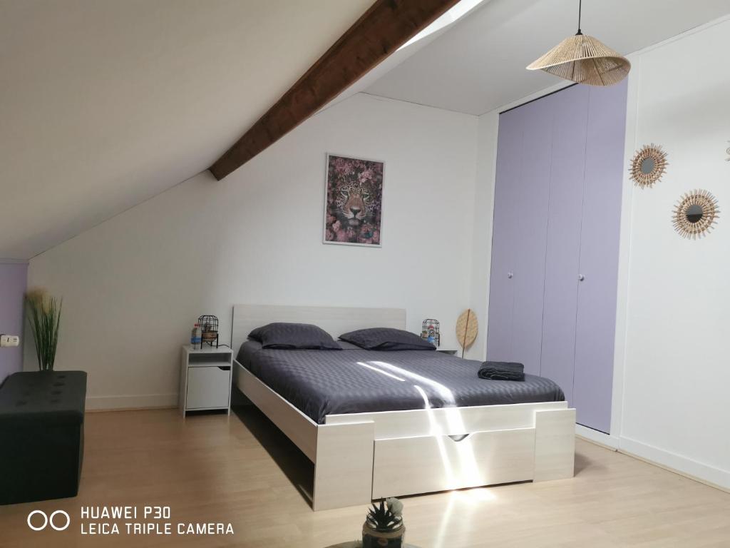 1 dormitorio con 1 cama en una habitación blanca en 2 chambres privatives avec Sdb proche circuit, en Arnage