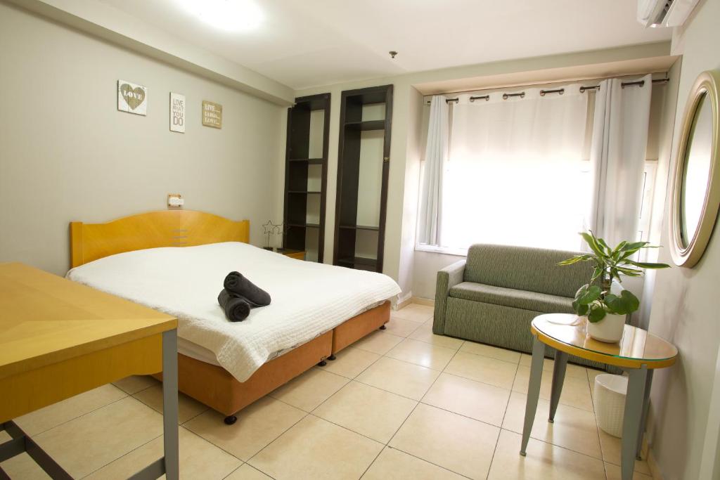 埃拉特Little Prince Hostel-5 Min Walk To The Beach的一间卧室配有一张床、一张沙发和一张桌子