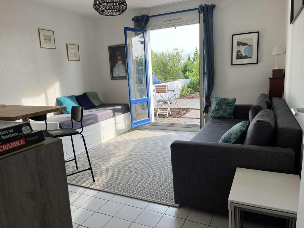 un salon avec un canapé et une table dans l'établissement Studio avec jardinet, proche plage et commerces, La Guérinière - FR-1-224B-594, à La Guérinière
