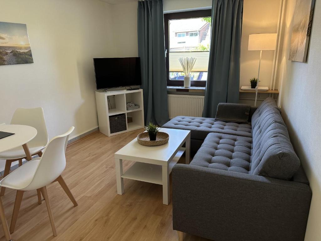 a living room with a couch and a table at Gästehaus Bremer in Cuxhaven