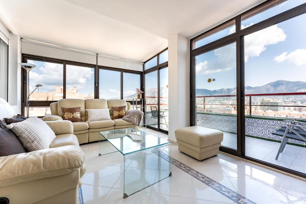 - un salon avec un canapé et une table en verre dans l'établissement MalagaSuite Skyviews Fuengirola, à Fuengirola