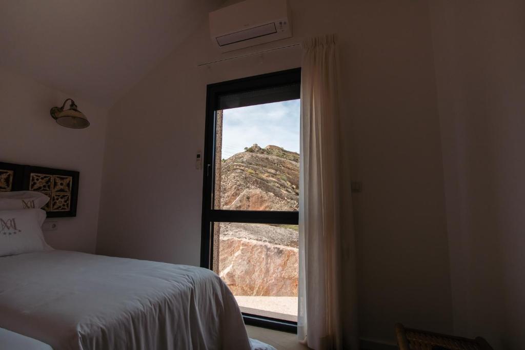 a bedroom with a window with a mountain view at Chalês - Maria Alva in Marialva