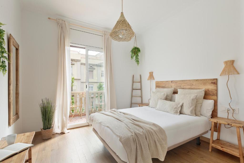 バルセロナにあるKeyFamily Sweet Homeの白いベッドルーム(大型ベッド1台、窓付)