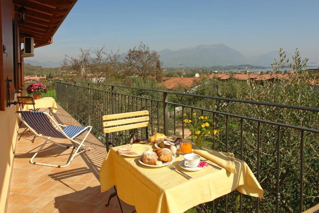a table with a plate of food on a balcony at B&B Agli Ulivi in Manerba del Garda
