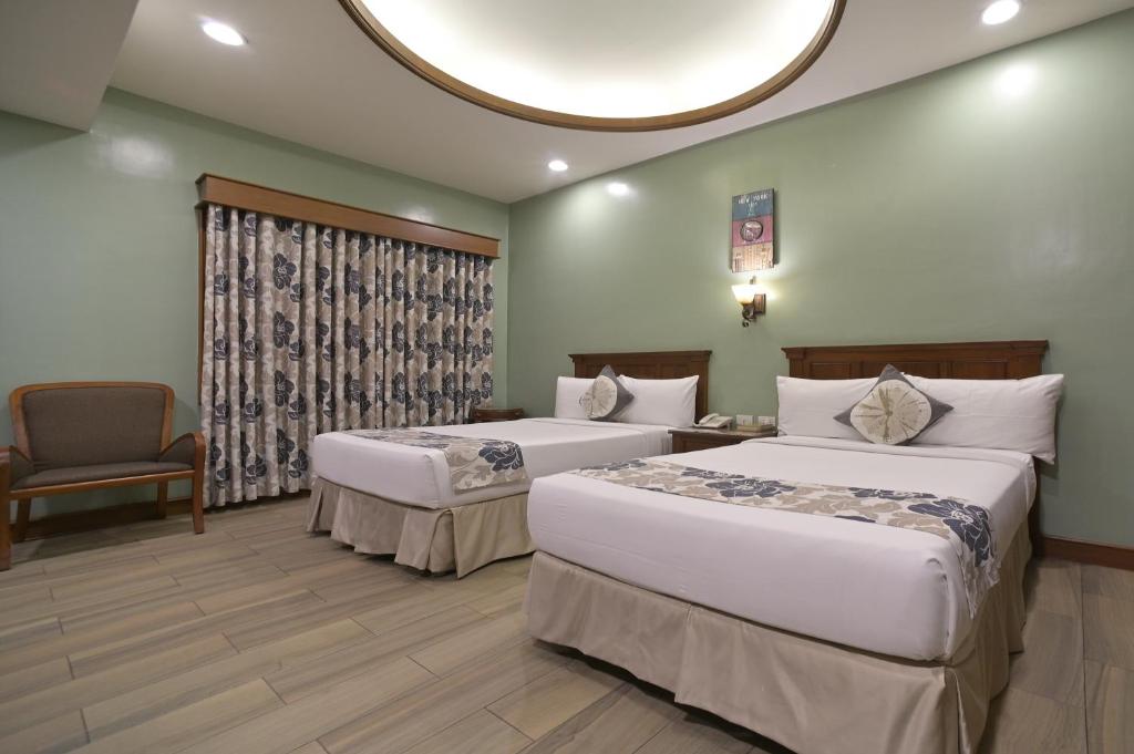 Postel nebo postele na pokoji v ubytování Paragon Hotel and Suites