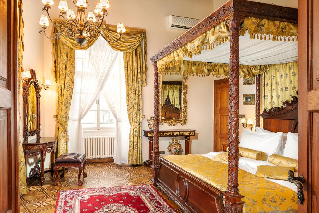 ein Schlafzimmer mit einem Himmelbett und einem Spiegel in der Unterkunft Hotel U Prince Prague by BHG in Prag