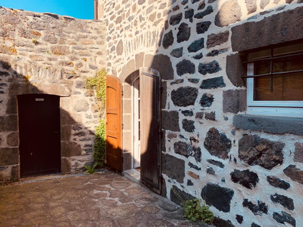 a stone building with a door and a window at Maison studio avec jardin in Salers