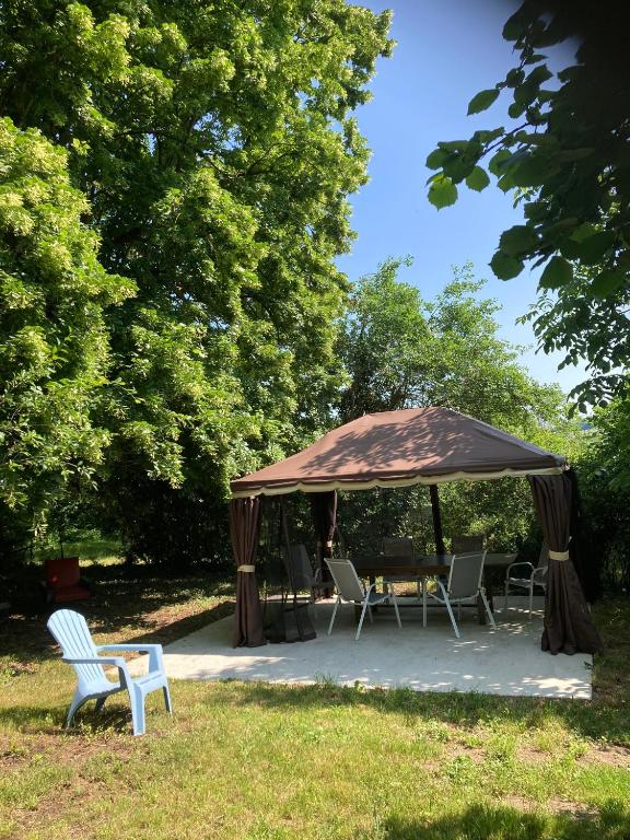 un gazebo avec des chaises et une table dans un parc dans l'établissement Le petit monas, à Civaux
