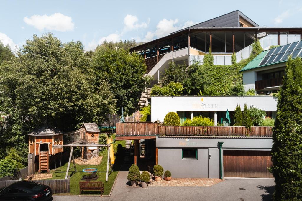 a house with a garage and a house with a solarium at Annas Garten inklusive Super Sommer Card Sommer 2026 in Serfaus