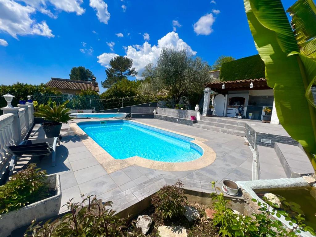 - une piscine dans une cour avec une terrasse dans l'établissement VILLA AVEC PISCINE, à Le Tignet