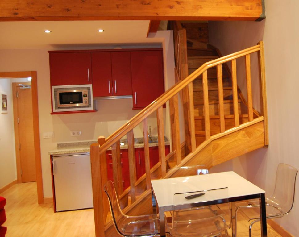 una cocina con una escalera y una mesa y una cocina en Apartamentos Plaza Mayor, en Llanes