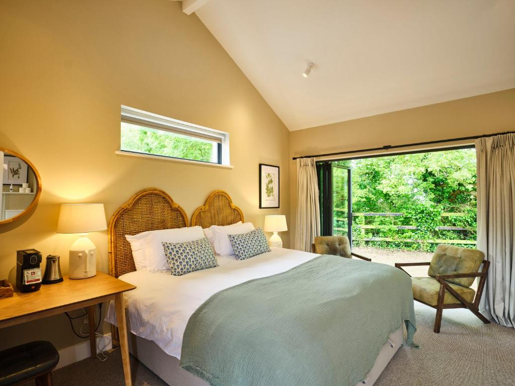 a bedroom with a bed and a desk and a window at The Weeping Willow in Bury Saint Edmunds