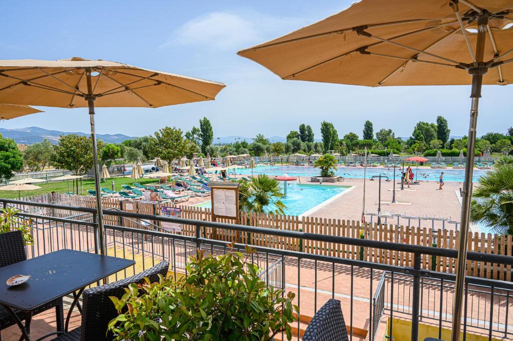 a view of a swimming pool with tables and umbrellas at Poggio all'Agnello Sport & Family Holidays in Populonia