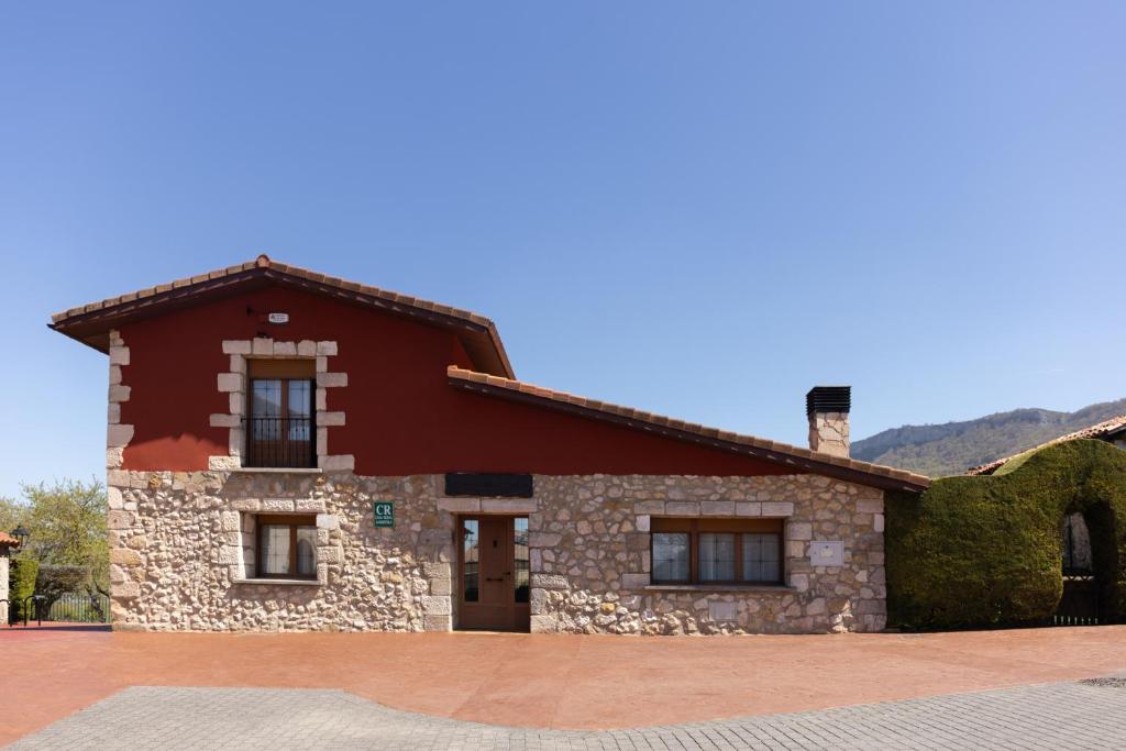 a stone house with a red roof and windows at Legaire Etxea in Ibarguren