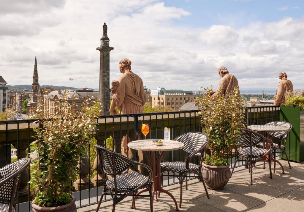 um grupo de pessoas numa varanda com uma mesa e cadeiras em Gleneagles Townhouse em Edimburgo