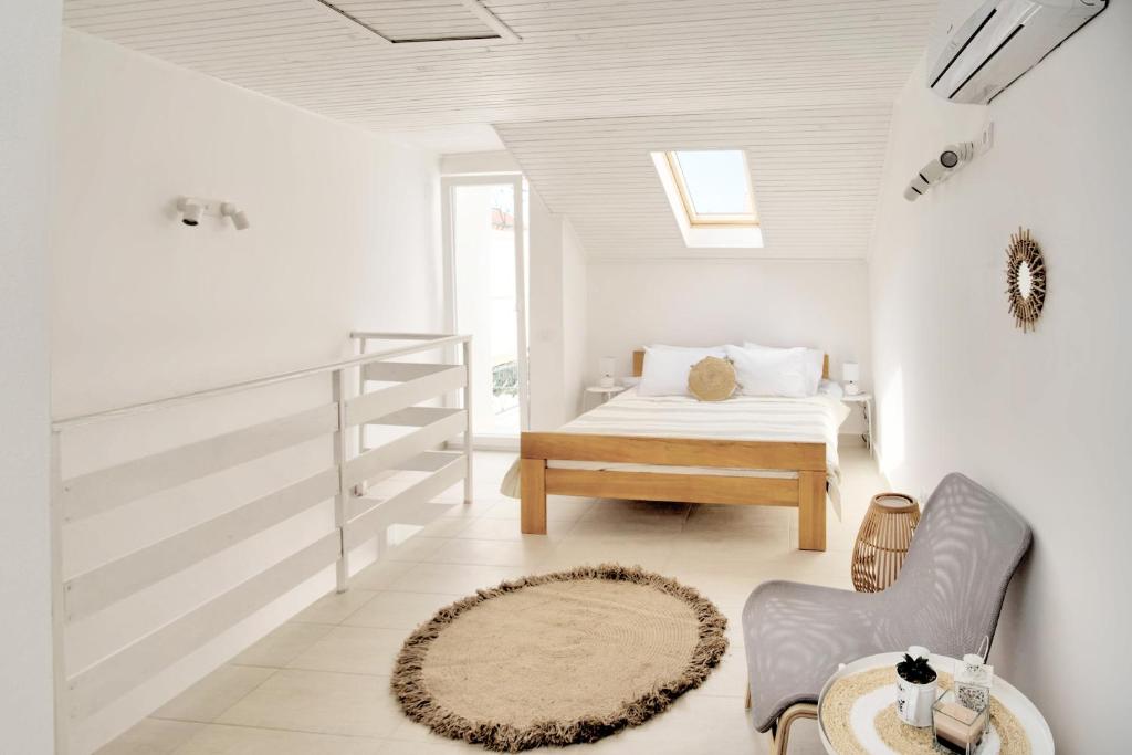 a white bedroom with a bed and a table at Bokeljski cvijet in Baošići