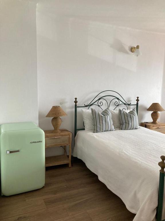 a bedroom with a bed and a refrigerator in it at Casa da Nazaré in Portinho da Arrábida