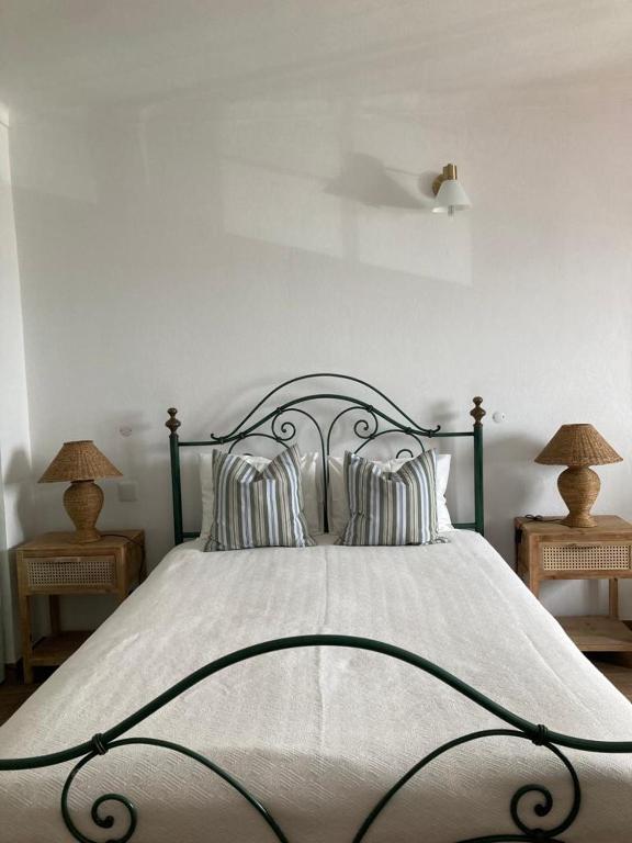 a bedroom with a large bed with two lamps at Casa da Nazaré in Portinho da Arrábida