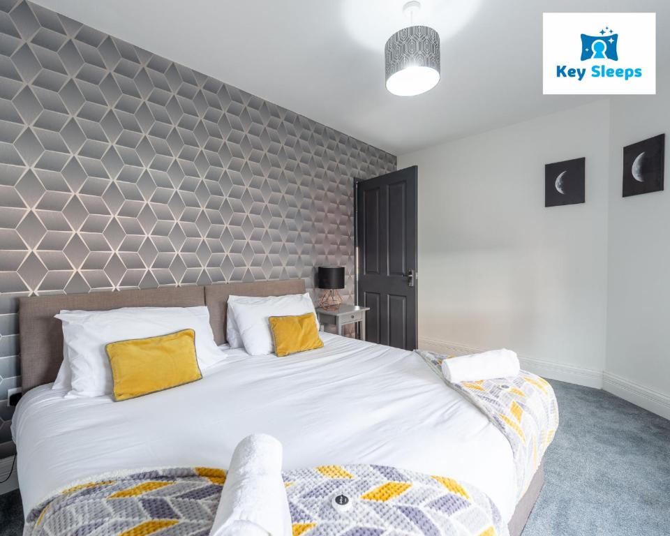 um quarto com uma cama grande e almofadas amarelas em Five Bedroom Spacious Modern House By Keysleeps Short Lets Workington Lake District Beach em Workington