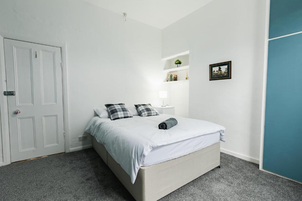 una camera da letto bianca con un letto con lenzuola e cuscini bianchi di Peaceful House near Pearson Park a Hull