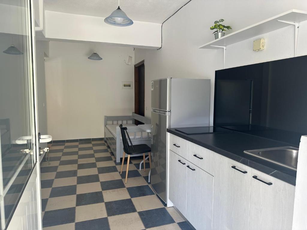 een keuken met een koelkast en een geruite vloer bij Koala Place in Vasiliki