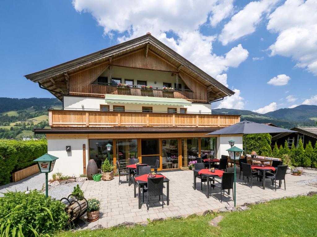 un edificio con mesas y sillas delante de él en Haus Tirol, en Brixen im Thale