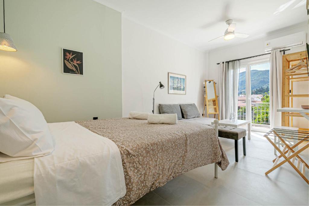 a white bedroom with a bed and a window at Terranova beach apartment - Menta in Ýpsos
