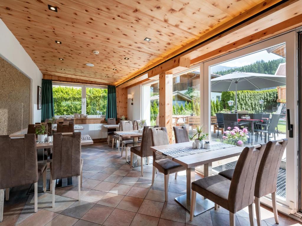 a dining room with tables and chairs and windows at Haus Tirol in Brixen im Thale