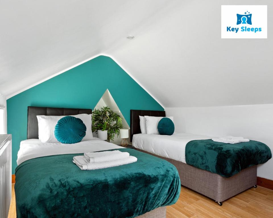 a bedroom with two beds with green sheets and blue walls at Spacious House By Keysleeps Short Lets Canterbury With Garden Contractors Leisure in Kent
