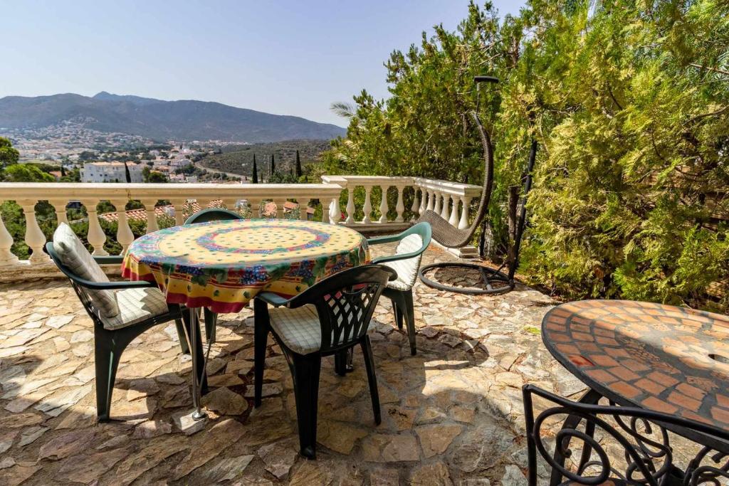 een tafel en stoelen op een patio met uitzicht bij Grifeu 12 Estudio con vistas de montaña y costa in Llança