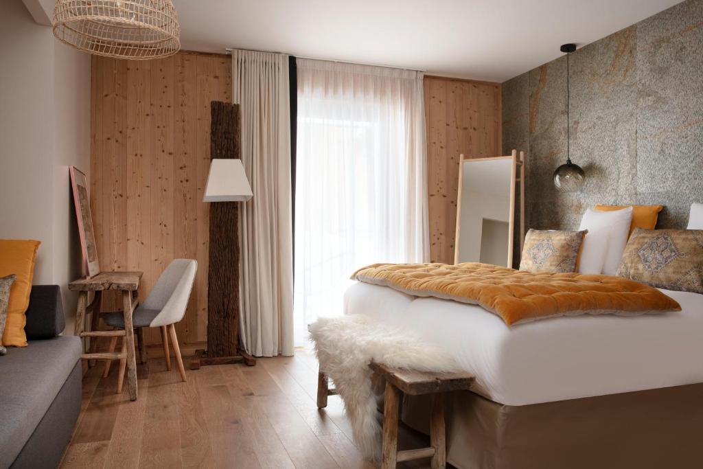 a bedroom with a large bed and a couch in it at Grandes Rousses Hotel &amp; Spa in L&#39;Alpe-d&#39;Huez