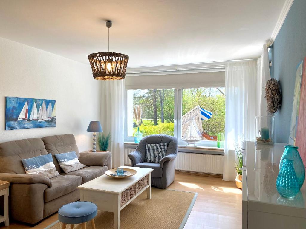 ein Wohnzimmer mit einem Sofa und einem Tisch in der Unterkunft MEI71 Ferienwohnung Strandlust F in Niendorf