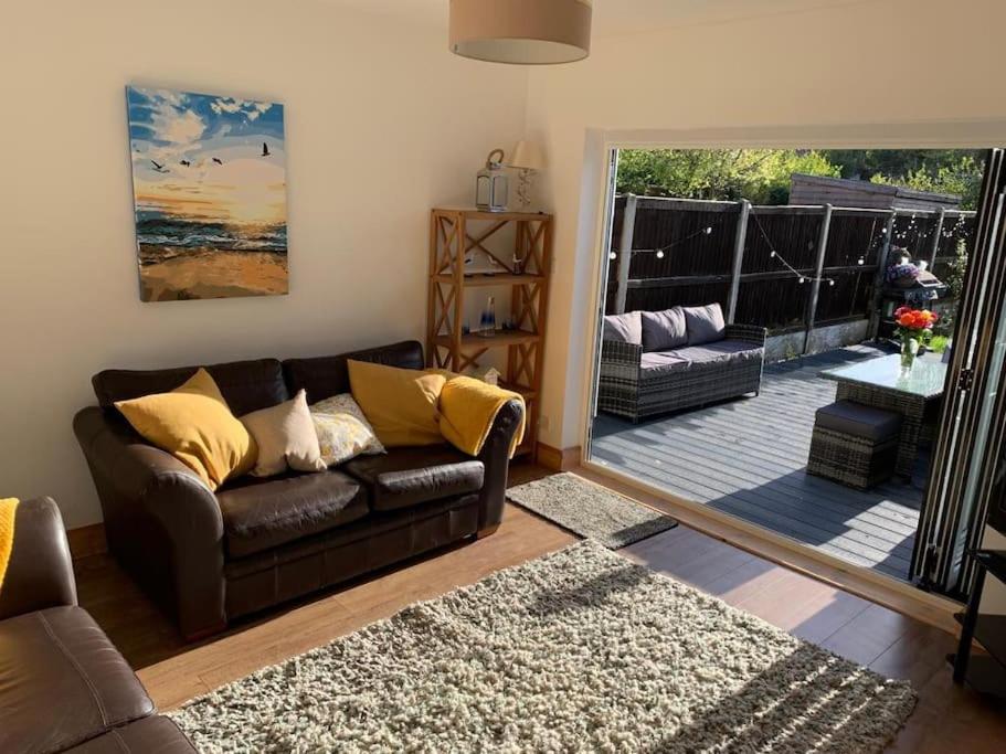 a living room with a couch and a patio at Dot's Escape - 2 bed bungalow. in Kent