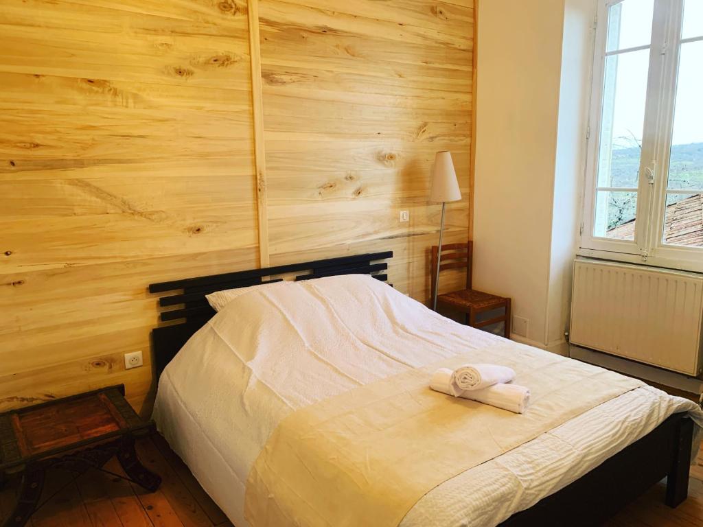 a bedroom with a bed with a wooden wall at La Forge de Béduer in Béduer