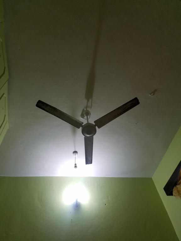 a ceiling fan in a room with a light on it at Amar ak house in Mombasa