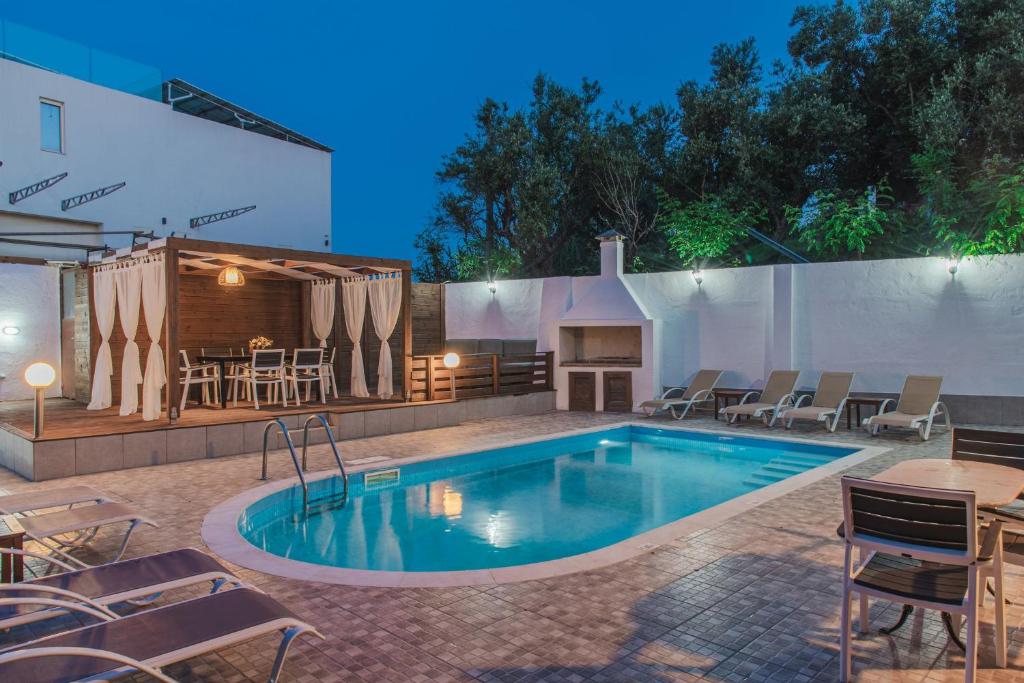 a swimming pool with a patio and a fireplace at Villa Danae in Laganas