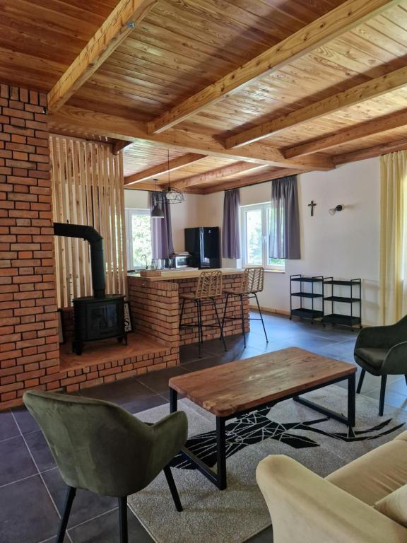 een woonkamer met een tafel en een open haard bij Siedlisko na Roztoczu in Szastarka
