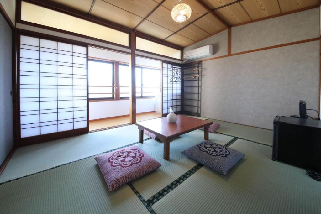 a living room with a table and two mats at さきみや in Goto