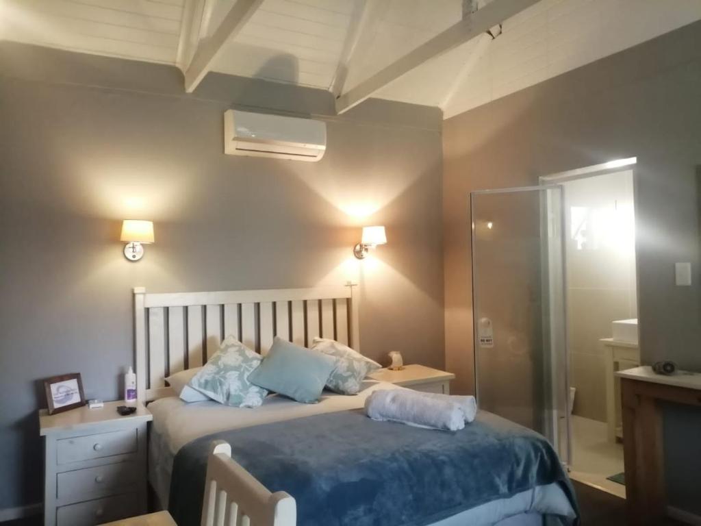 a bedroom with a bed with blue pillows at Seaforth Guesthouse in East London
