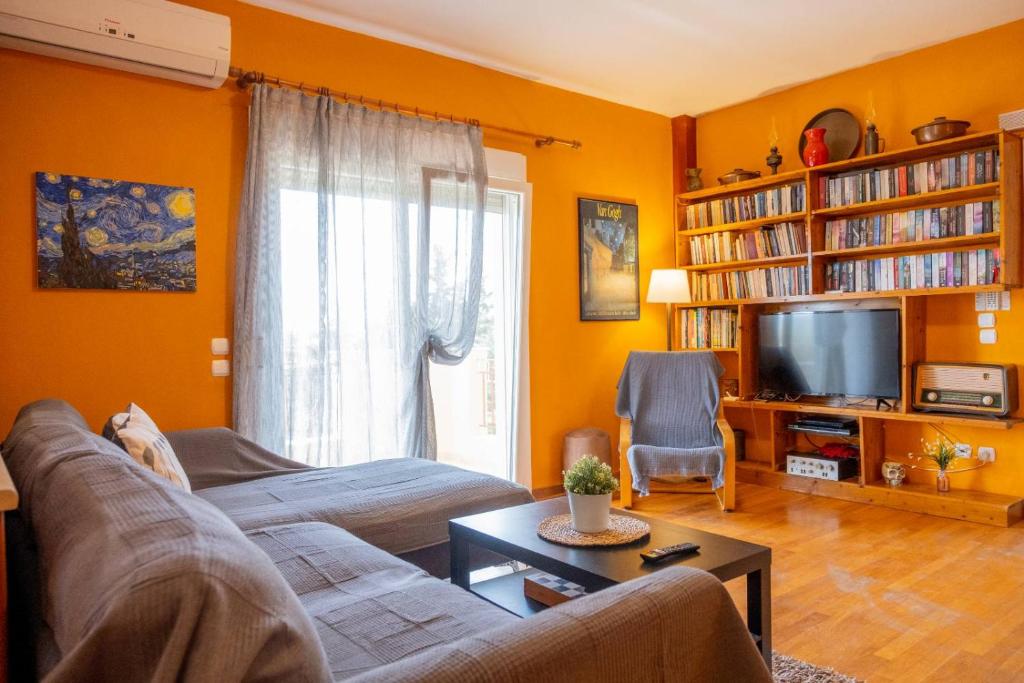 a living room with a couch and a tv at Natural Oasis Villa in Nea Fokea