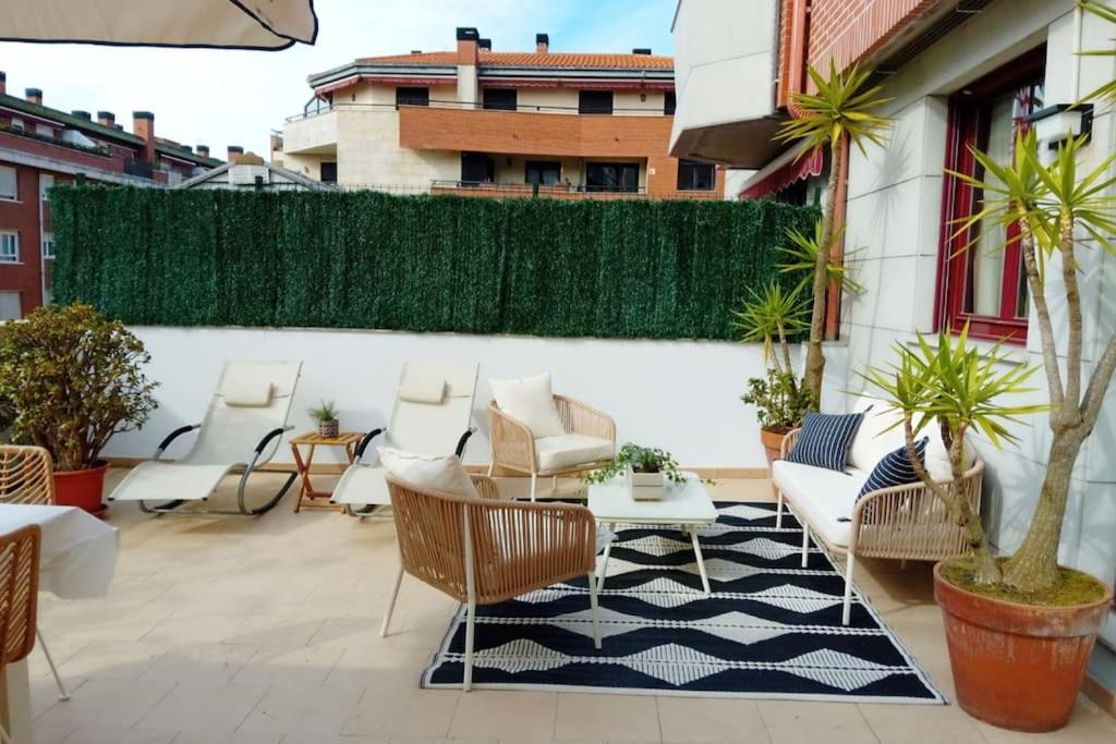un patio con sillas y una mesa en un edificio en Bajo con impresionante terraza, en Castro Urdiales