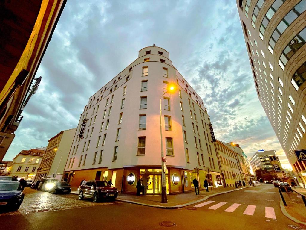 un edificio alto en una calle de la ciudad con luz de la calle en B&B Hotel Prague City en Praga