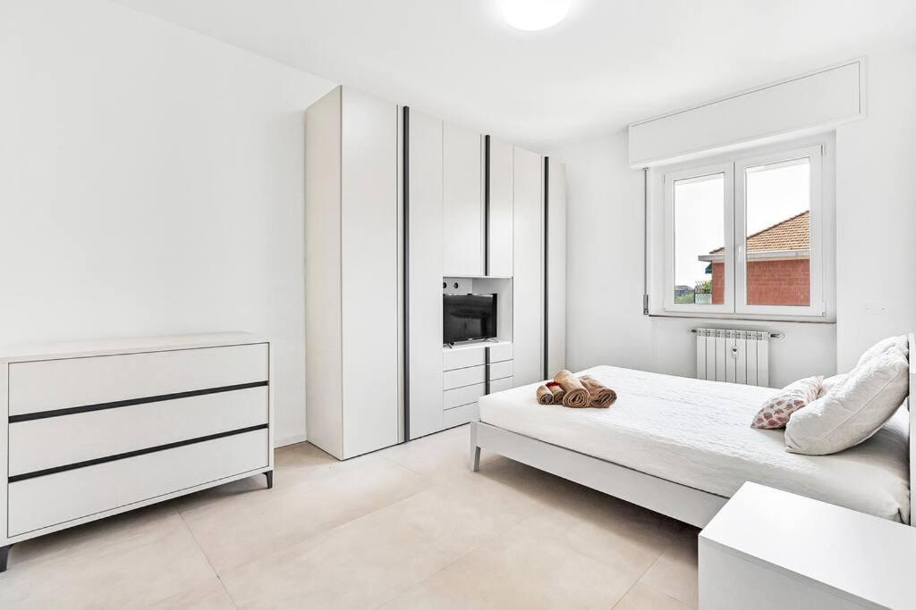 een witte slaapkamer met een bed en een televisie bij Alessia's Flat - Caroli in Milaan