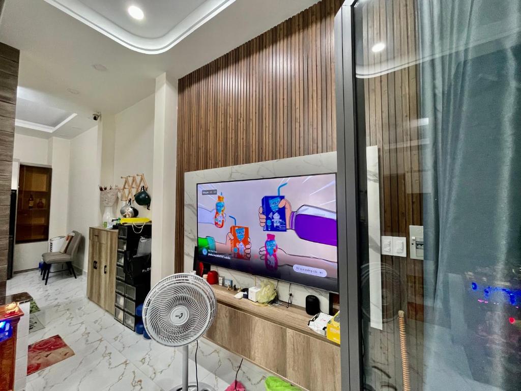 a living room with a tv and a fan at Sweet Home LGBTQ in Ho Chi Minh City