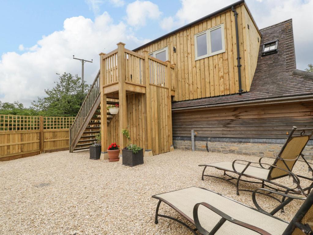 a wooden house with a deck and two chairs at The Attic at Redmond Bottom in Wells